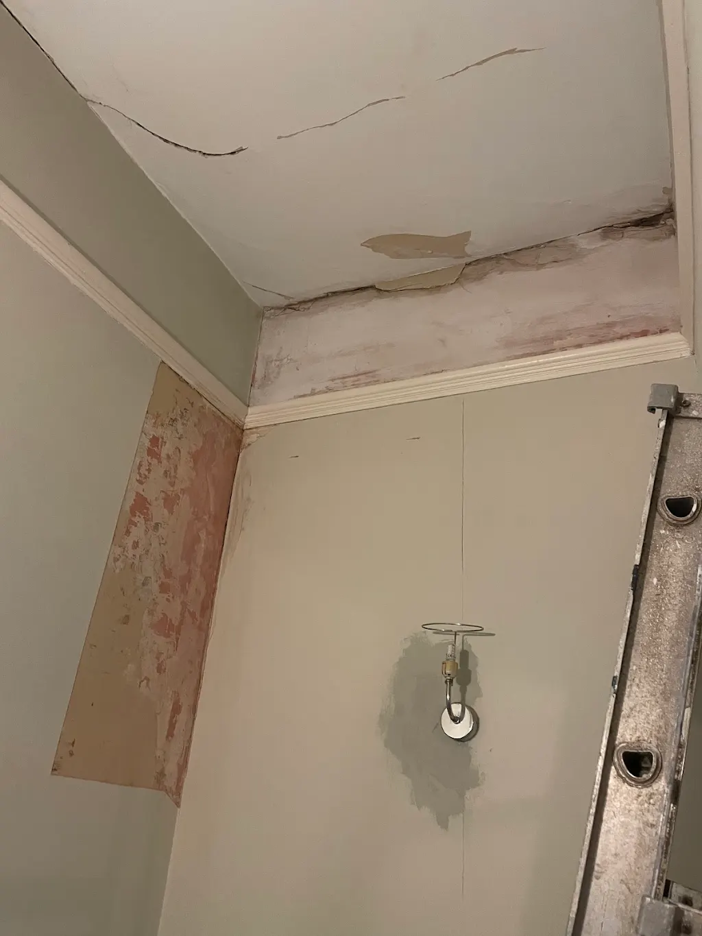 Before — Peeling wallpaper stripped back to sound plaster, Living room · Hampton Hill